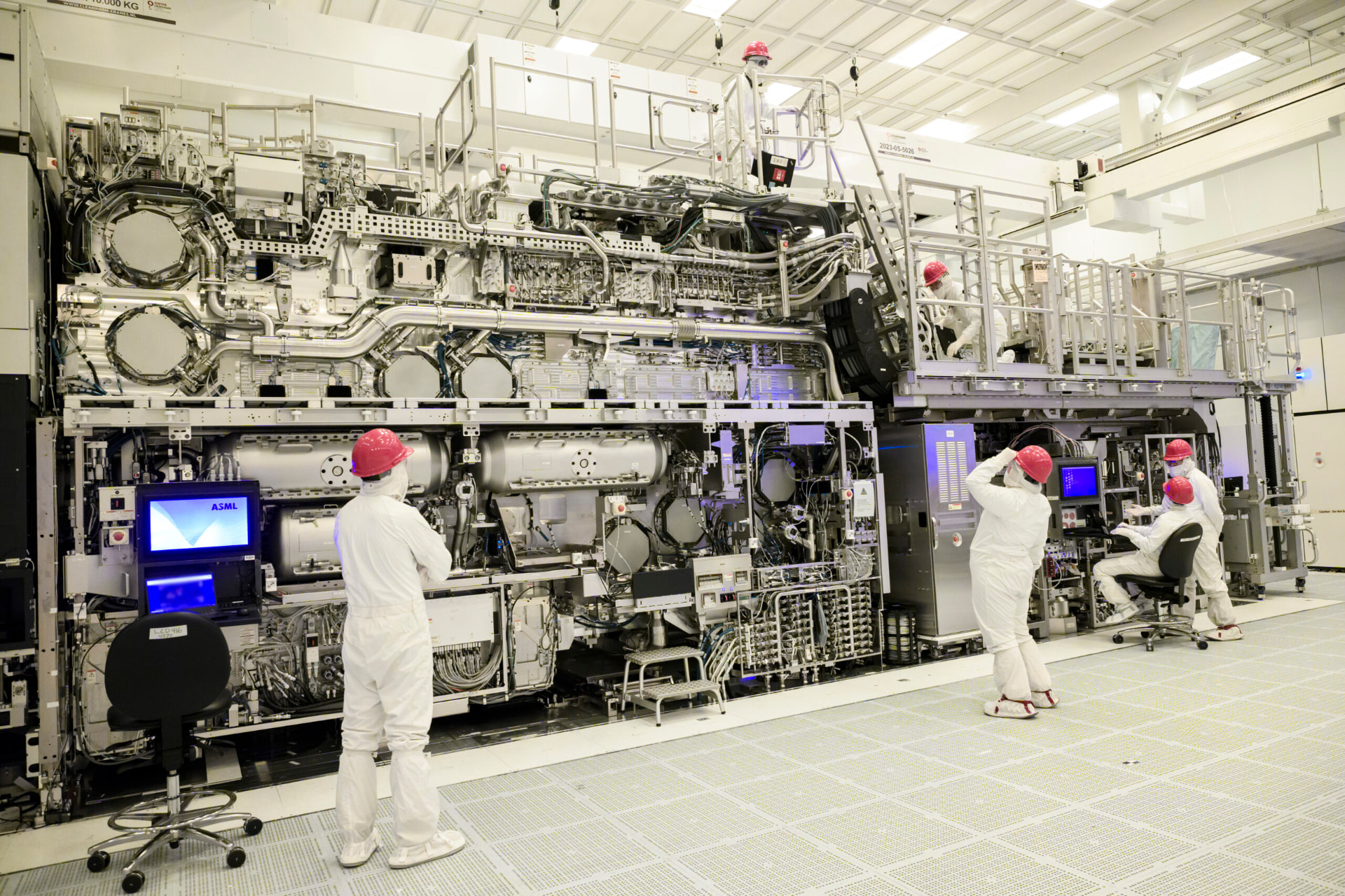 Technicians in cleanroom suits working on an ASML High-NA EUV lithography machine